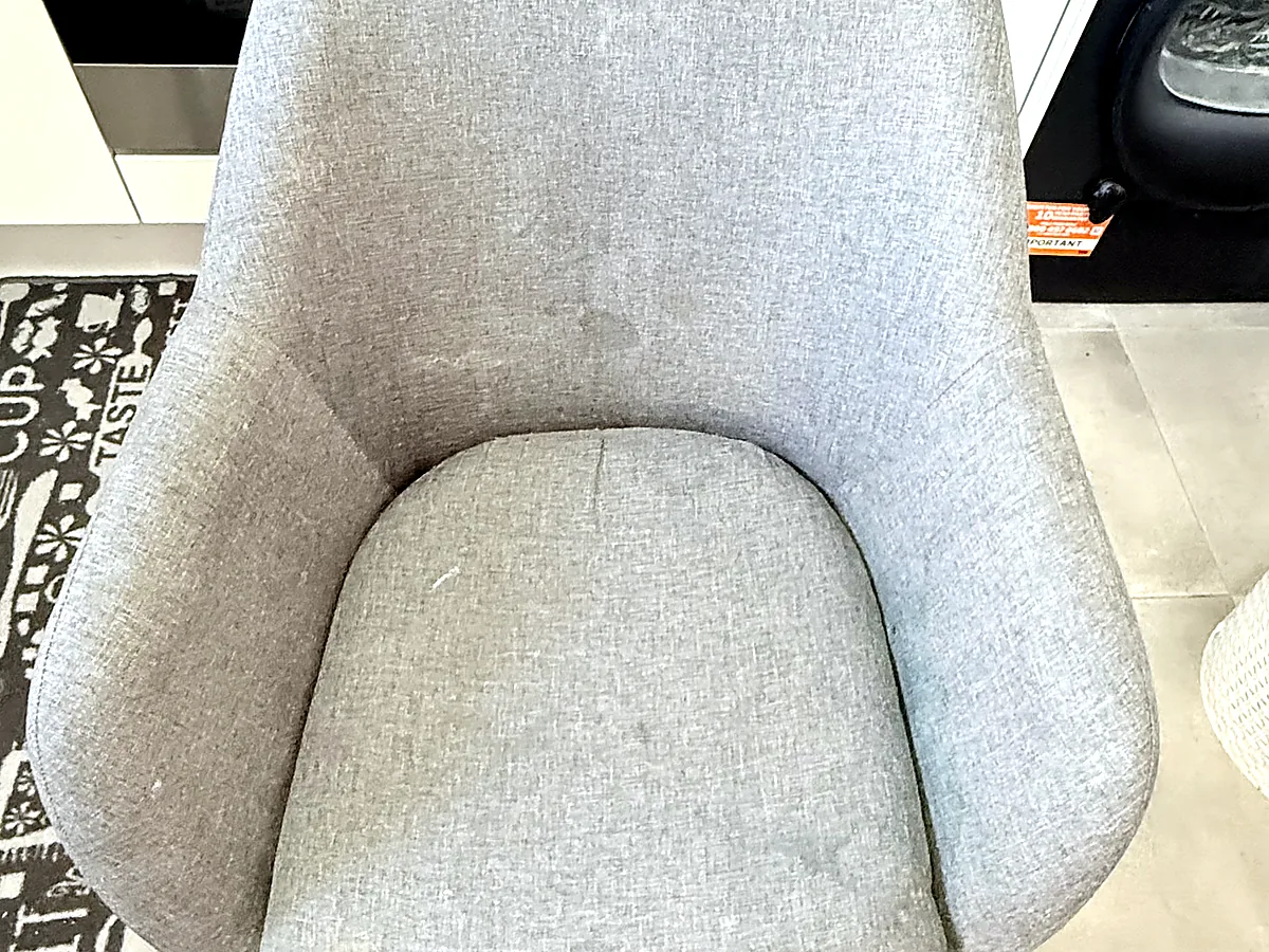 Before upholstery cleaning on a grey fabric chair